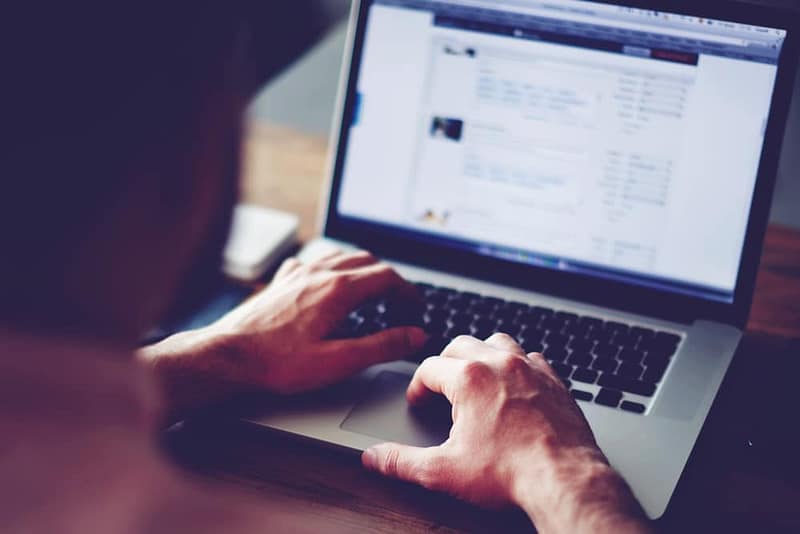 A person typing on a laptop computer.