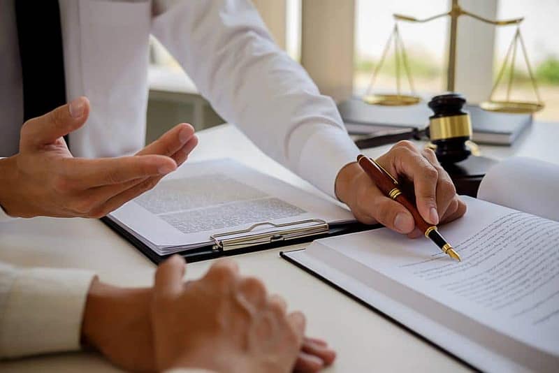 Two people signing a document at a desk in South Dakota.
