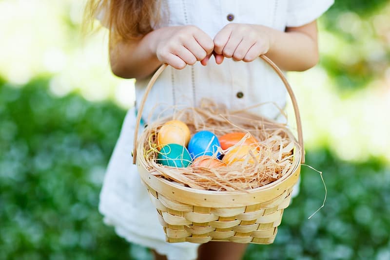 A little girl enjoying the Great Outdoors RV while holding a basket full of Easter eggs.