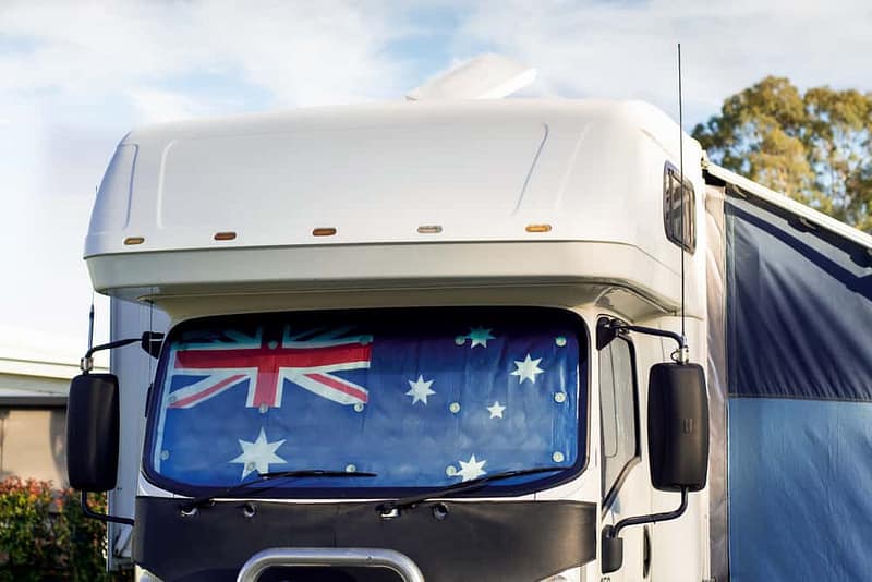 A white Victorian caravan with an Australian flag on it.