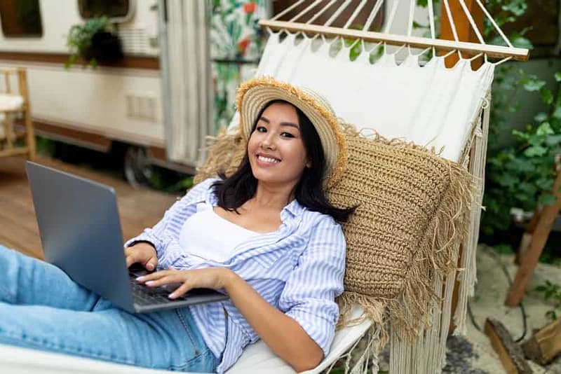 A woman working in a hammock with her laptop.