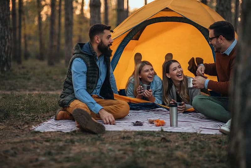 A group of friends sitting around a tent in the East Bluff Campground in Keweenaw County.