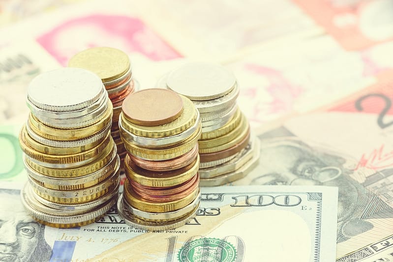 A stack of coins on top of a pile of money, representing funding for Florida State Parks Foundation as part of the Governor's Budget Request.