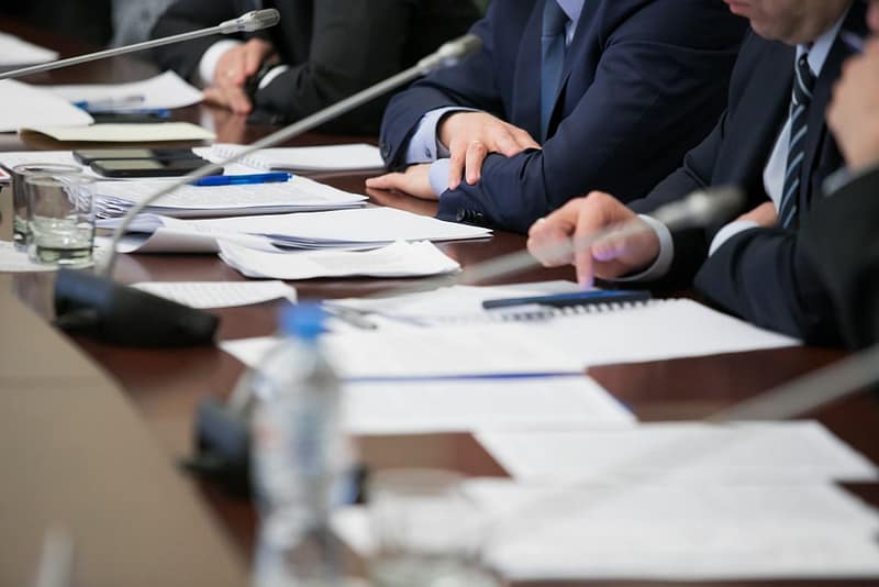 A group of business people sitting at a conference table.