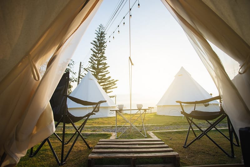 A group of luxury camping tents with chairs in front of them at a Safari Campground Resort.