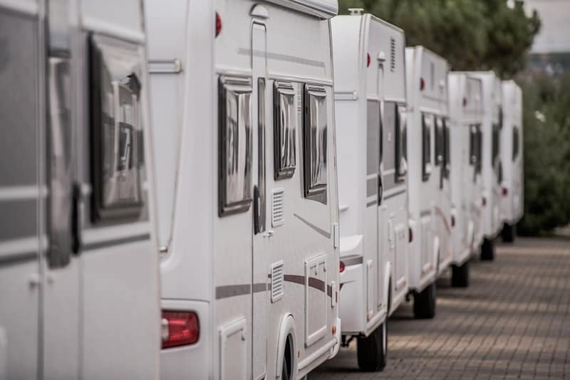 A row of white RVs parked next to each other at an RV dealership in Oshkosh.