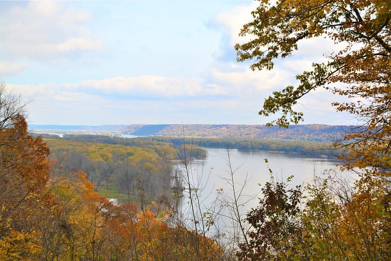 A scenic view of a river and trees in the fall at Pikes Peak State Park.