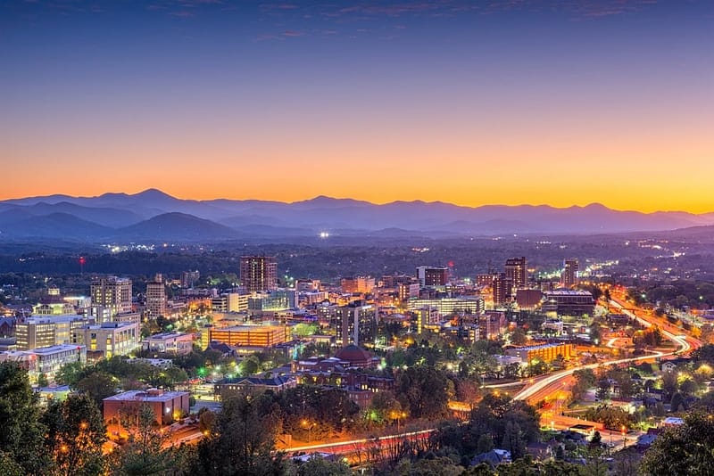 A premier camping destination in Asheville, with mountains in the background at dusk.