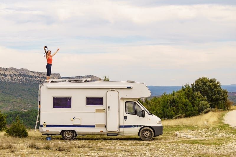 A woman from Girl Camper Magazine is standing on top of an RV.