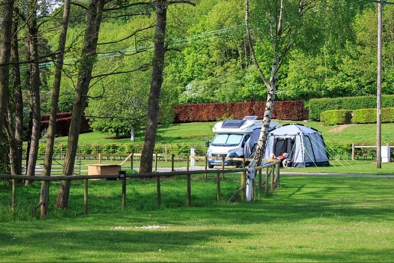 A camper van parked in the grassy field of Poston Mill Touring Park.