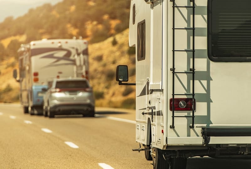 A Lazydays RV is driving down the road with a car behind it while traveling from Ohio to Arizona.