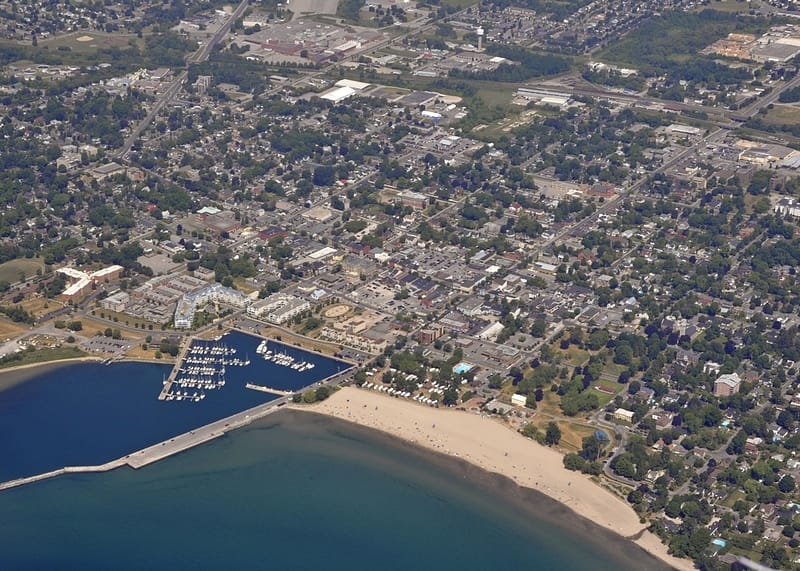 A revitalized town featuring Victoria Park with an aerial view of a marina and a beach.