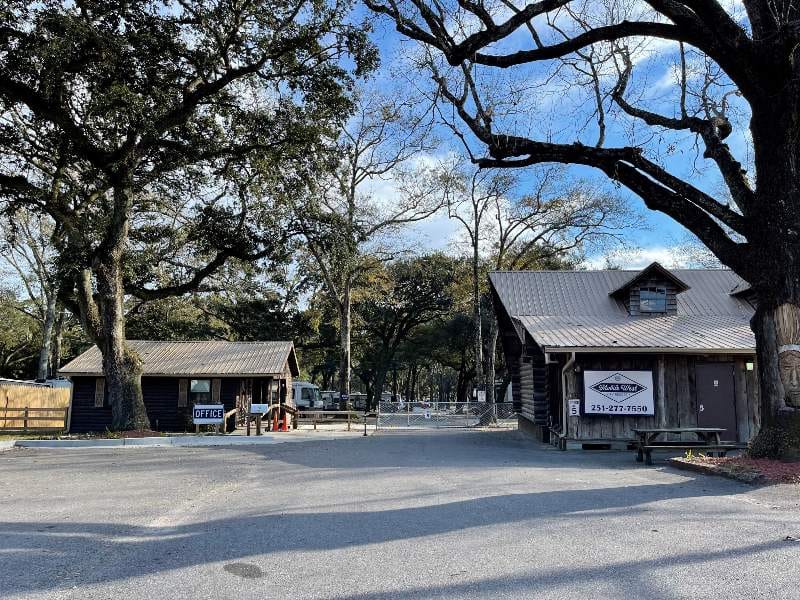 The entrance to Mobile West RV Resort, formerly known as Johnny's RV Park, with a tree in the background.