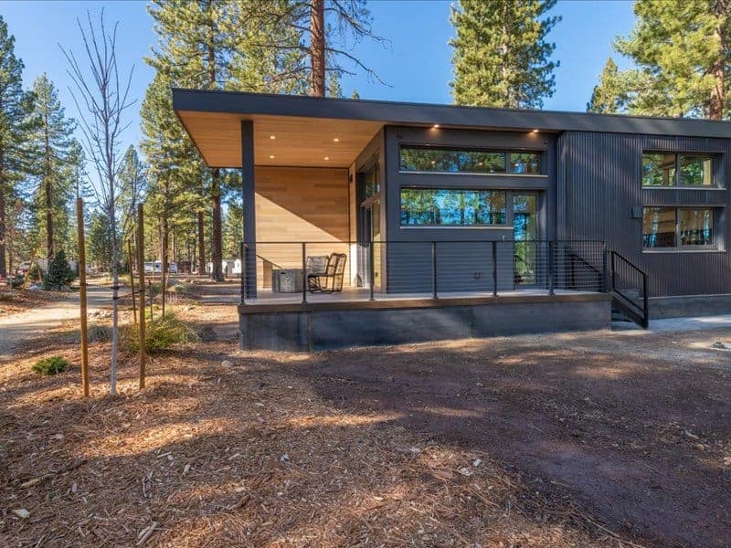 An upscale black cabin nestled in the tranquil woods, offering an escape from everyday life. Perfect for those seeking the amenities of an upscale RV site while experiencing the rustic charm of Village Camp at Roberts