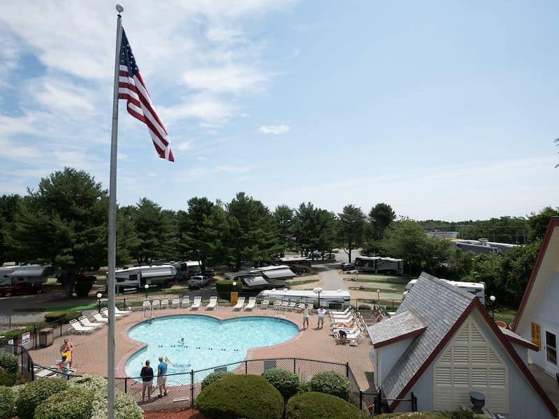 An American flag is flying over a swimming pool at an RV park in Wells Beach.