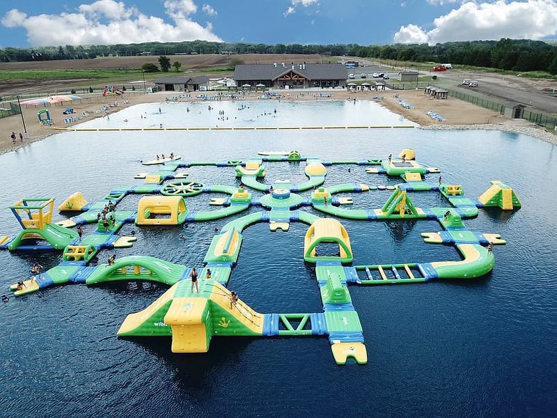 An inflatable water park with upgrades and expansions in the middle of a lake near Wisconsin campgrounds.