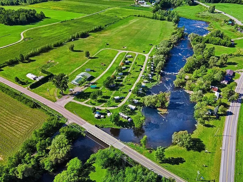 An aerial view of a riverside camping area and a babbling brook.