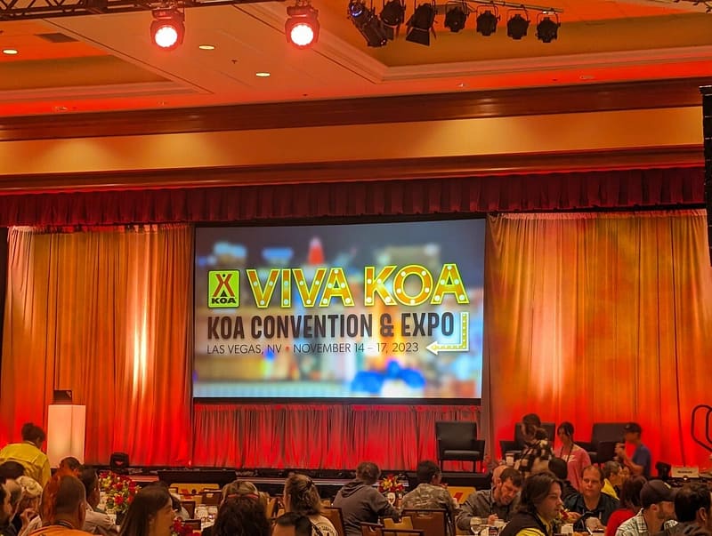 A group of people sitting at a table at a convention during the General Session.