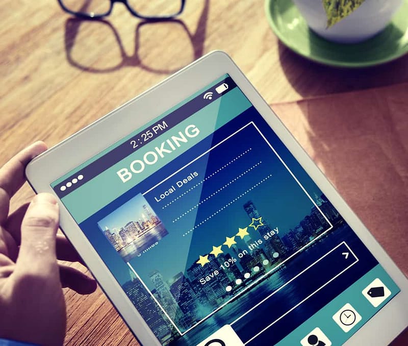 A person holding a tablet with a Campsite Reservations app on it.