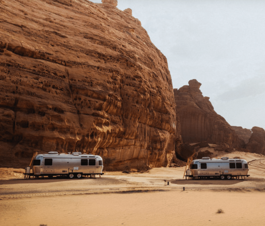 Two Airstream trailers parked in the desert.