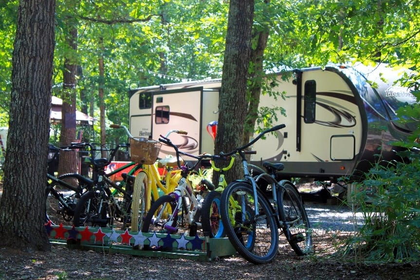 Bicycles parked in the woods near an RV at a campsite during Memorial Day weekend.