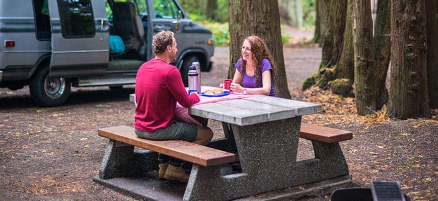Two people enjoying an interpretive program at a picnic table in Gulf Islands National Park Reserve.