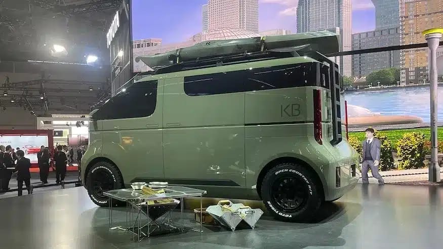 A Toyota EV camper van is on display at an auto show.