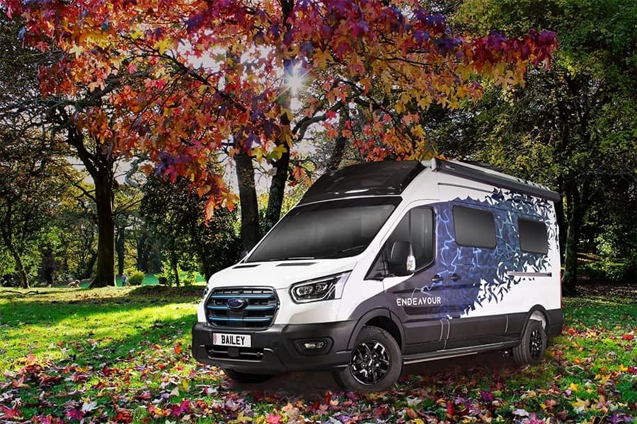 A Bailey of Bristol transit parked in a park with autumn leaves.