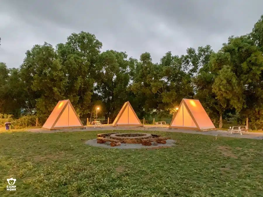 Camp Monk's air frame glamping tents set up in the middle of a grassy field.