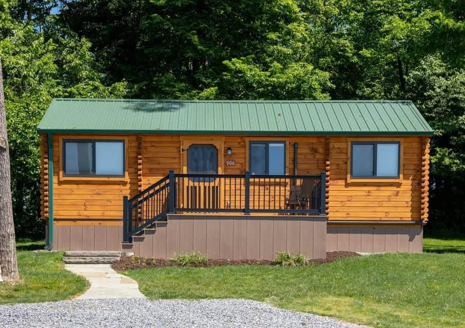 A cozy log cabin nestled in the woods of Jellystone Park Camp-Resort, offering a serene retreat away from city life.