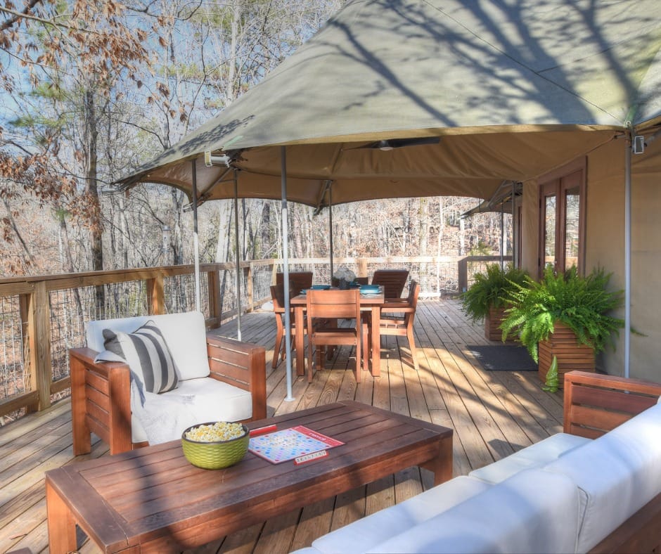 A glamping deck with stylish furniture and a cozy tent, perfect for a luxurious camping experience at our Nashville resort destination.