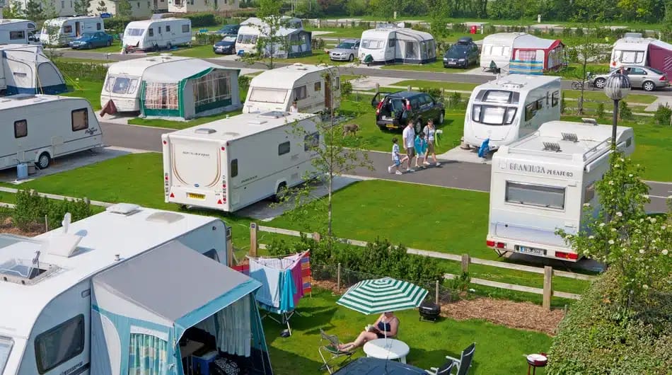 A group of camper vans parked in a grassy area, ready for new adventures in 2022.