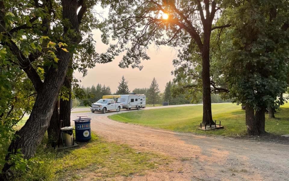 A rv parked on a dirt road at a Manitoba campground.