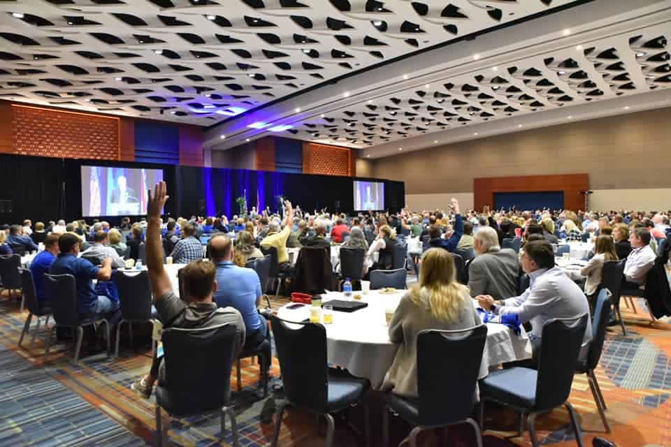 A large room full of people sitting at tables, attending the ARVC Outdoor Hospitality Conference Expo.