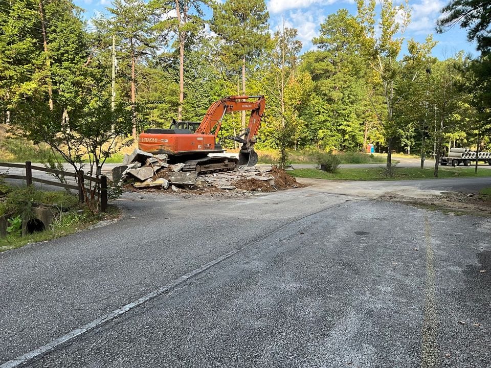 An excavator is digging up a road in Oak Mountain State Park for renovations.