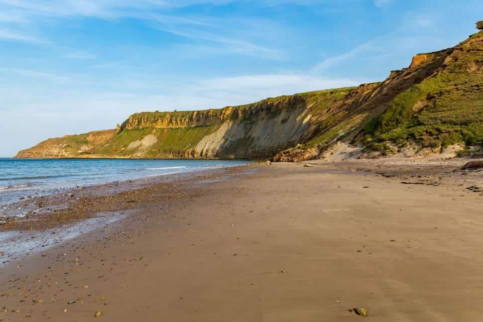 Cayton Bay, one of UK's popular beach spots, is a sandy beach with cliffs in the background, attracting campers from far and wide.