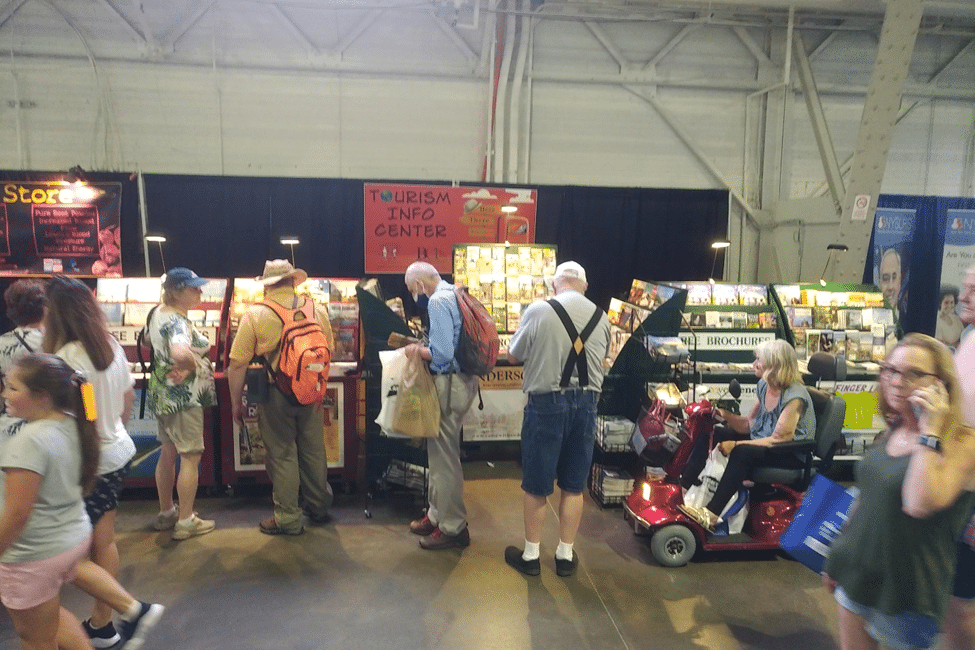 A group of Merchantry and Tourism Partners browsing books at a convention.