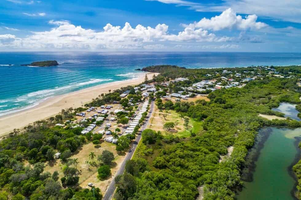 An aerial view of a beach and ocean, showcasing the serene beauty of Tweed Holiday Parks.