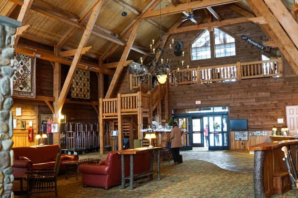 The lobby of a log cabin with a stone fireplace at a new campground.