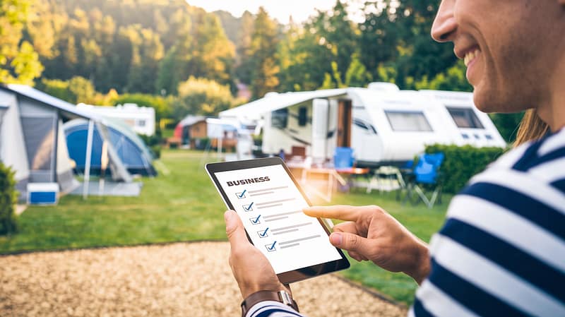 Person using tablet at a campsite.
